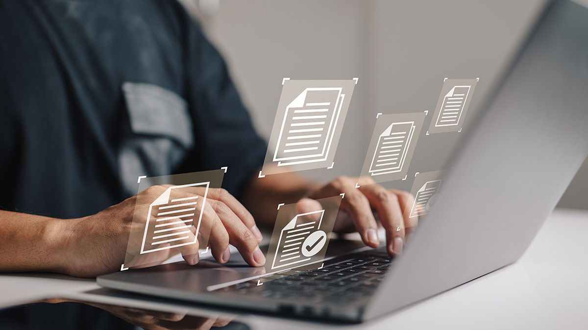 A person types on a laptop with floating digital document icons representing data processing, document management, or automated content review in a modern digital workflow.